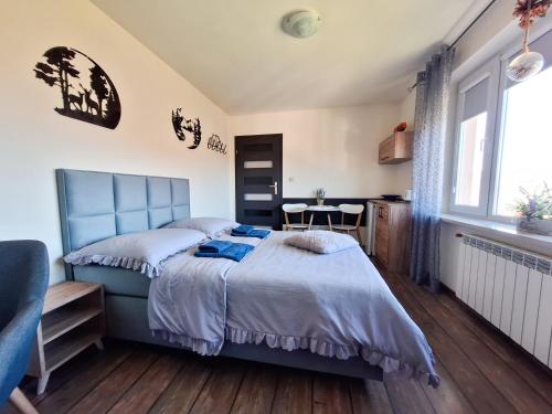 Schlafzimmer mit einem blauen Bett und einem Tisch in der Unterkunft Noclegi Fregata - Pokoje Gościnne w Solinie 661-459-339 in Solina