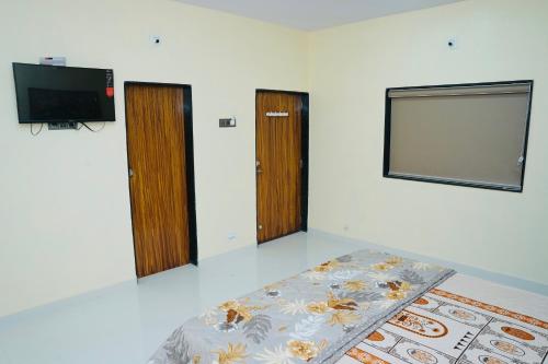 Habitación con 2 puertas, TV y cama en Dwarkesh Farm&Resort, en Somnath