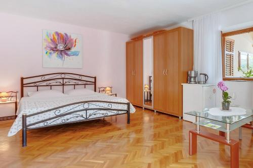 a bedroom with a bed and a glass table at House ROSSELLA with cozy apartment and rooms close to the beach in Nerezine