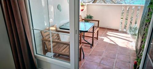 balcón con mesa y puerta de cristal en Guesthouse Alliya en Dubrovnik