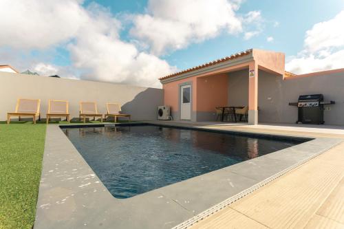 a swimming pool in front of a house with chairs at Best Houses 108 - Casa Sea Mountain in Ferrel