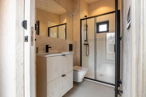 y baño con aseo, lavabo y ducha. en Hello Zeeland - Tiny House Zeeuwse Liefde 11 en Westkapelle