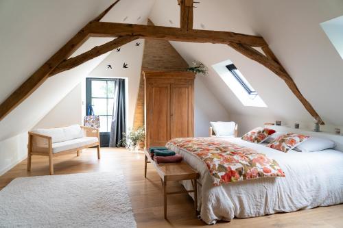 - une chambre mansardée avec un grand lit dans l'établissement La Grande Roche, à Chambellay