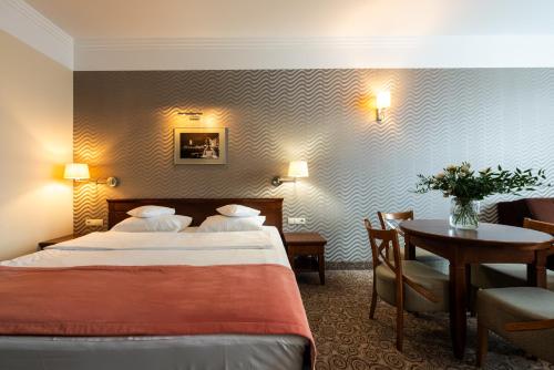 Hotel Esperanto في بياويستوك: غرفة الفندق بسرير وطاولة