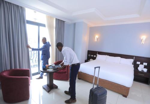 due uomini in una stanza d'albergo con un letto di East Gate Appartement Gust House ad Addis Abeba