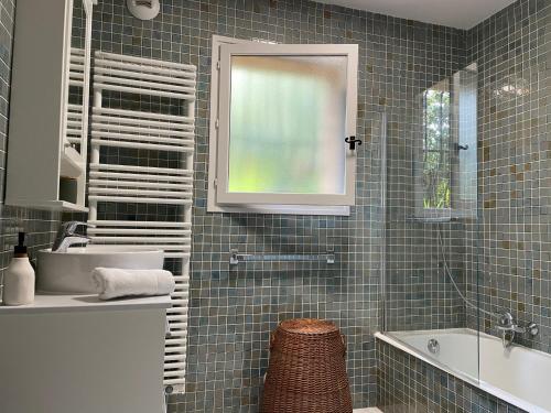 een badkamer met een wastafel, een bad en een spiegel bij Villa de Charme au coeur du Cap-Ferrat in Saint-Jean-Cap-Ferrat