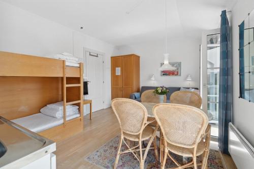 een kamer met een tafel en stoelen en een stapelbed bij Strandslot in Allinge