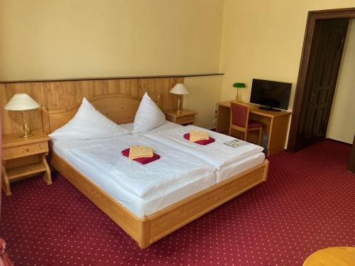 a bedroom with a large bed with two napkins on it at Hotel garni Am Dippeplatz in Quedlinburg