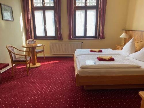 a hotel room with a bed and two windows at Hotel garni Am Dippeplatz in Quedlinburg