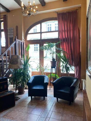 a living room with two chairs and a large window at Hotel garni Am Dippeplatz in Quedlinburg