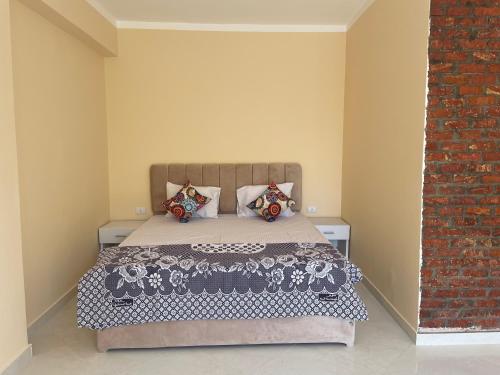 a bedroom with a bed with a brick wall at Karima House in Luxor