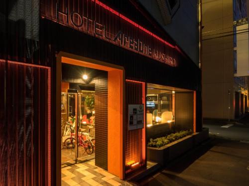 a store front with an orange door on a city street at Hotel AreaOne Kushiro in Kushiro