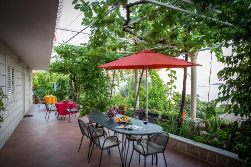 a patio with a table and chairs and an umbrella at Studio Apartments Andrijana in Mlini