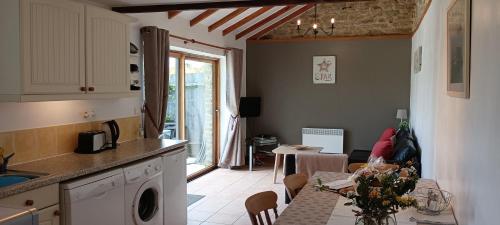 a kitchen and a dining room with a table and a kitchen at Keranmeriet D near Pont Aven, Concarneau, beaches 15km in Melgven