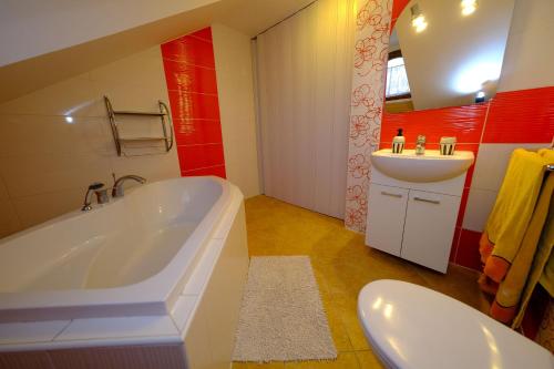a bathroom with a tub and a sink at Penzion Farma in Lednice