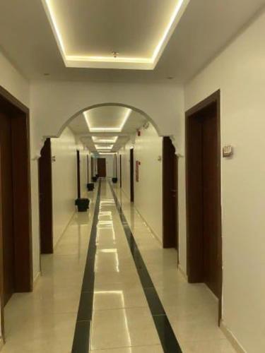 a hallway in a building with a long hallway at فنون راحتي للشقق المخدومة in Shariyah