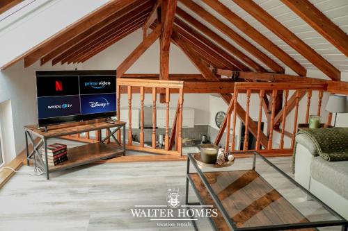 a living room with a large television in a barn at Fachwerkcharme: Wohnen in großer Maisonettwohnung in Villingen-Schwenningen