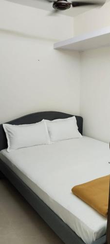 uma cama com lençóis brancos e almofadas em 1BR Apartment in Lower Parel em Mumbai