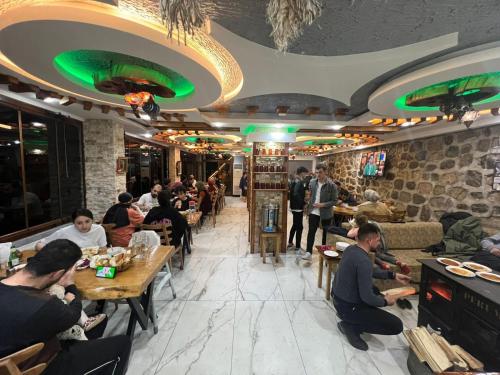 a group of people sitting at tables in a restaurant at Peruma otel bungalov in Çamlıhemşin