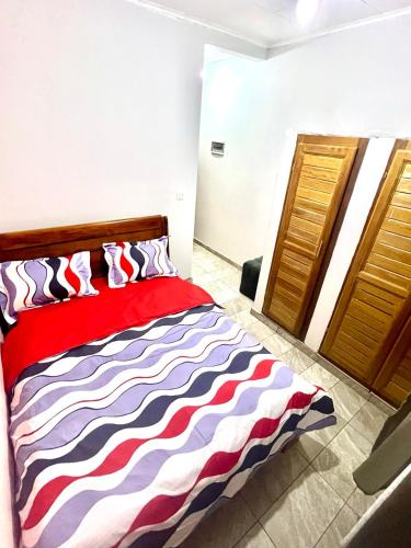 a bedroom with a bed with a colorful striped comforter at Hacienda Residence - Solar Energized in Yaoundé