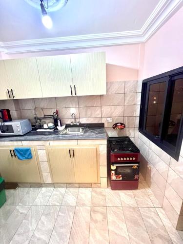 a kitchen with a sink and a stove top oven at Hacienda Residence - Solar Energized in Yaoundé