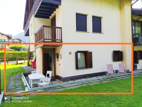 a house with a table and chairs in the yard at La casa dello scoiattolo primierotto in Tonadico
