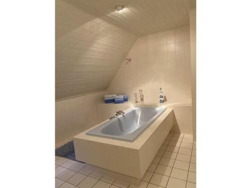 uma casa de banho com uma grande banheira branca num quarto em Holiday apartment Möwennest em Lindholm
