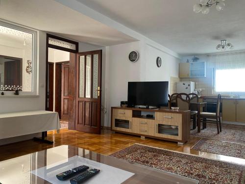 uma sala de estar com uma televisão de ecrã plano sobre uma mesa em Guest house Mostar em Mostar