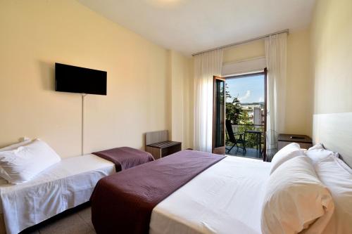 a hotel room with two beds and a balcony at Hotel Diano Marina Mhotelsgroup in Diano Marina