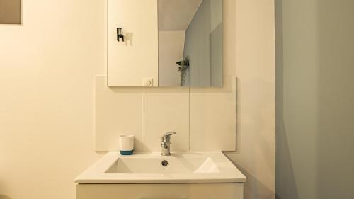 bagno con lavandino e specchio di Le New-Yorkais - Quartier historique - 4 pers. a Troyes