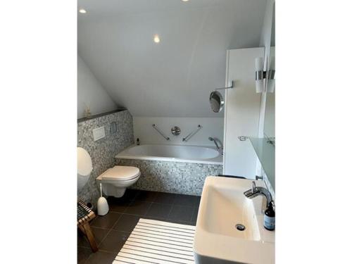 een badkamer met een bad, een toilet en een wastafel bij Holiday home Eifel H time out in Monschau