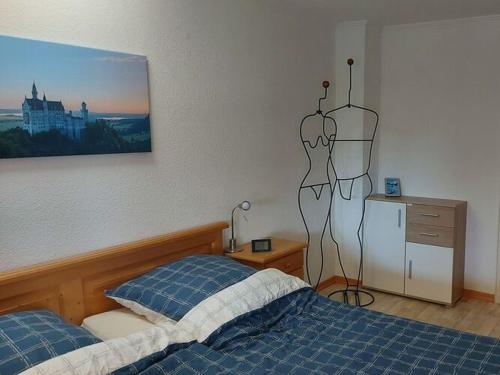a bedroom with a bed and a painting on the wall at Holiday apartment Edelweiss in Rieden am Forggensee