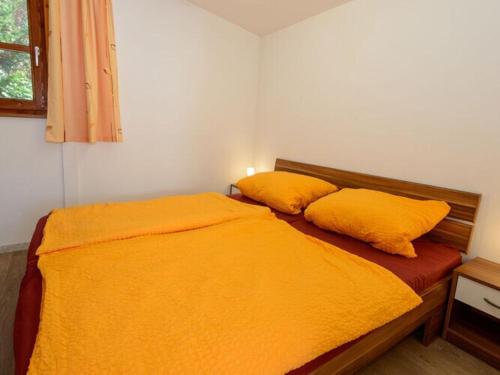 a bedroom with a bed with two yellow pillows at Holiday home sunshine in Bad Koetzting