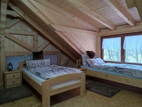 1 dormitorio con 2 camas en una cabaña de madera en Holiday home Waldhaus Edelweiss, en Scheßlitz