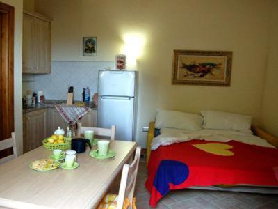 a kitchen with a bed and a table and a refrigerator at Una Finestra sul Silenzio Monolocale in Santa Luce