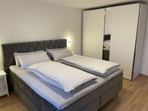 a bed with two white pillows on top of it at Holiday apartment Talblick in Unterlenningen