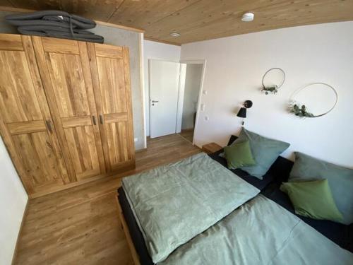 a bedroom with a bed and a wooden door at with private garden and mountain views in Oy-Mittelberg