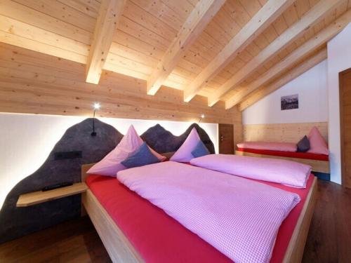 a bedroom with two beds in a room with wooden ceilings at Holiday apartment d'griabige in Farchant