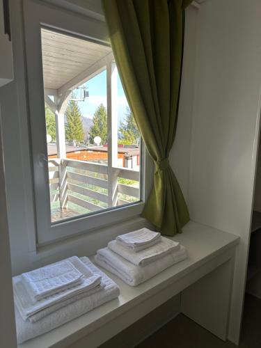 Magreglio的住宿－Campeggio Madonna Del Ghisallo，窗户旁的桌子上摆放着毛巾的窗户