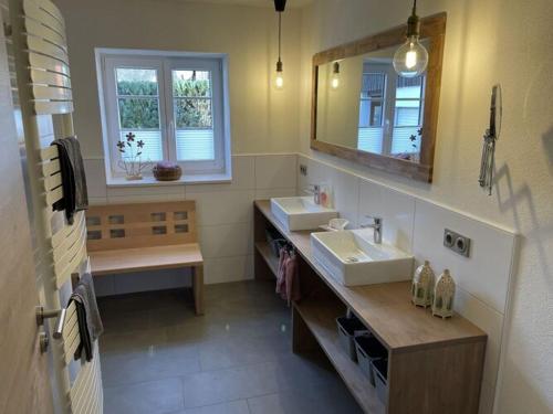 a bathroom with two sinks and a mirror at Holiday apartment Landzauber in Heideck