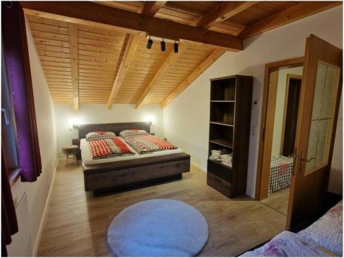 a bedroom with a bed and a wooden ceiling at Susanne - forest holiday village 