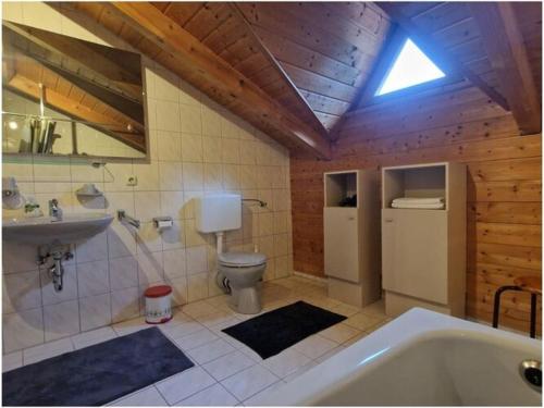 a bathroom with a tub and a toilet and a sink at Susanne - forest holiday village 