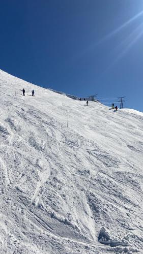 a group of people skiing down a snow covered slope at Chalet Epinel in Villaret