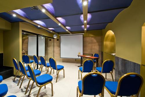a conference room with blue chairs and a whiteboard at BEST BALTIC Hotel Druskininkai Central in Druskininkai