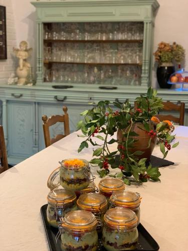 a tray of jars on a table with a plant at Maison d'Hôtes de l'Ancien Couvent des Carmes in Mortemart