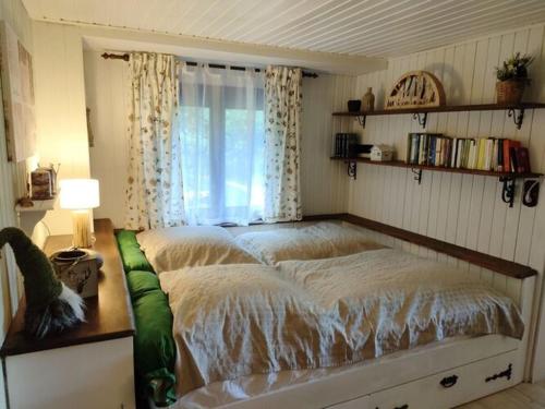a large bed in a bedroom with a window at Holiday home fairytale hut in Biedenkopf