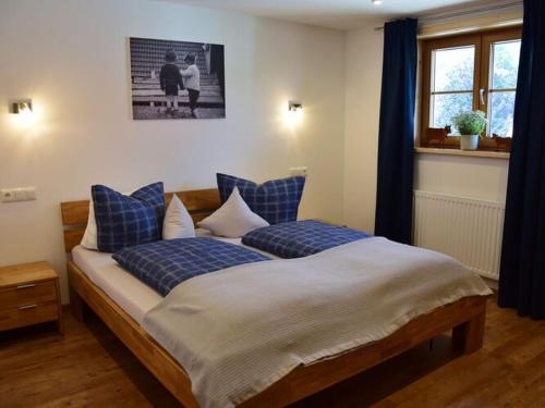 a bedroom with a large bed with blue pillows at at Gallus - Wetterstein in Oberstaufen