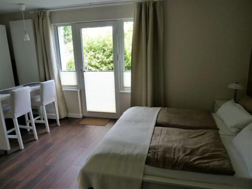 een slaapkamer met een bed, een tafel en een raam bij Apartment Ankenbrand in Randersacker