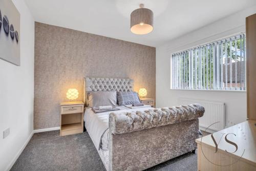 ein Schlafzimmer mit einem Bett und einem Sofa in der Unterkunft Stylish 3BR Home - Beautiful Garden - Parking in West Bromwich