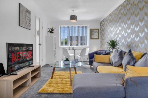 a living room with a couch and a tv at Modern 3BR Home in 9 Anson Rd Near Sandwell Hospital with Garden and Free Parking in West Bromwich